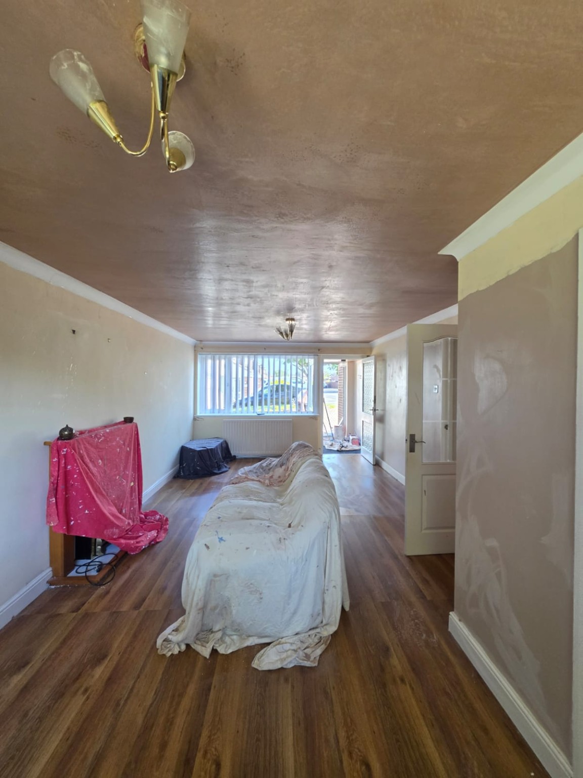 Freshly skimmed living room ceiling with furniture protected
